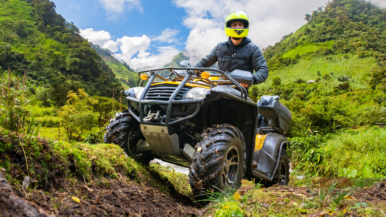 ATV rider drives over hills