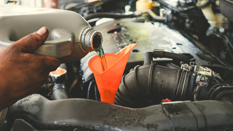 Mechanic pouring fresh transmission oil