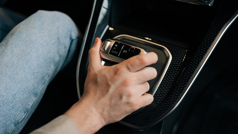 Man moving the gear lever in an automatic car