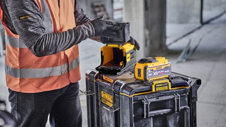 A person using a DeWalt battery adapter.