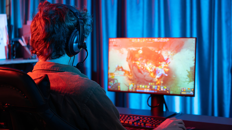 Guy sitting at his computer playing video games