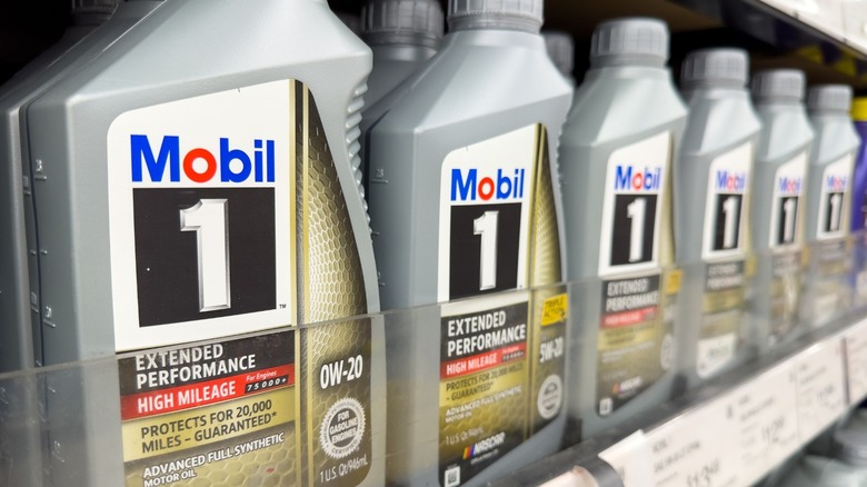 A row of high mileage engine oil containers on a shelf in a store