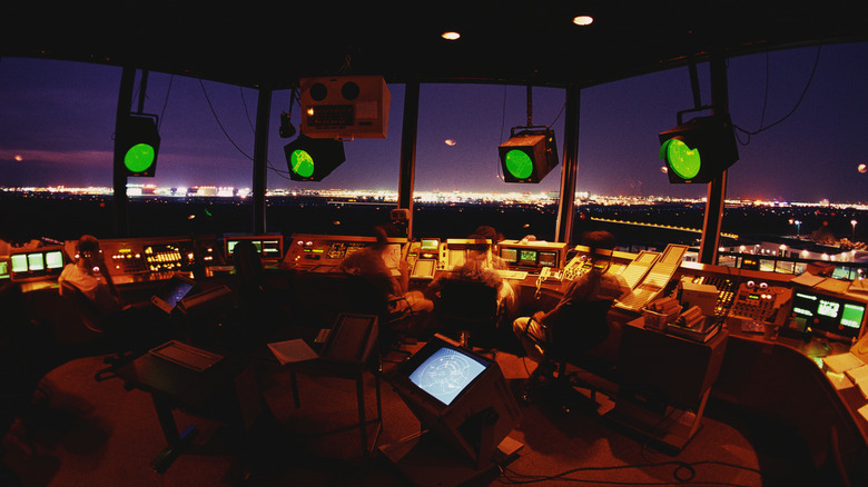 A busy air traffic control room operates at night