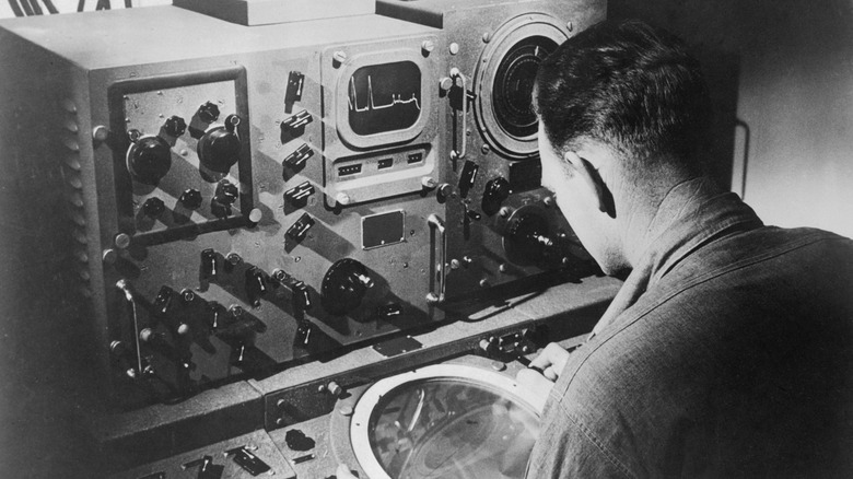 A soldier examines a radar screen during World War II