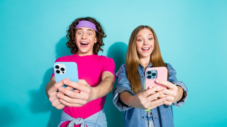 girl and guy taking selfies on iPhone