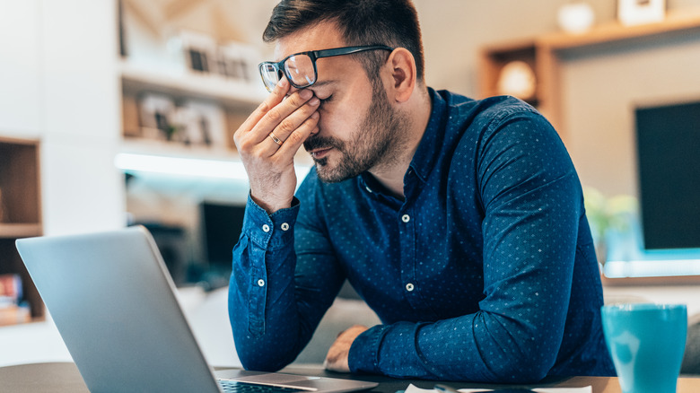 Frustrated man using laptop