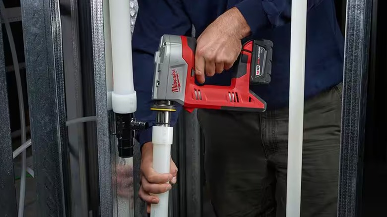 Person using Milwaukee M18 expansion tool on PEX piping