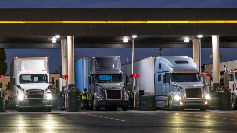 Semi-trucks and trailers parked gas stations