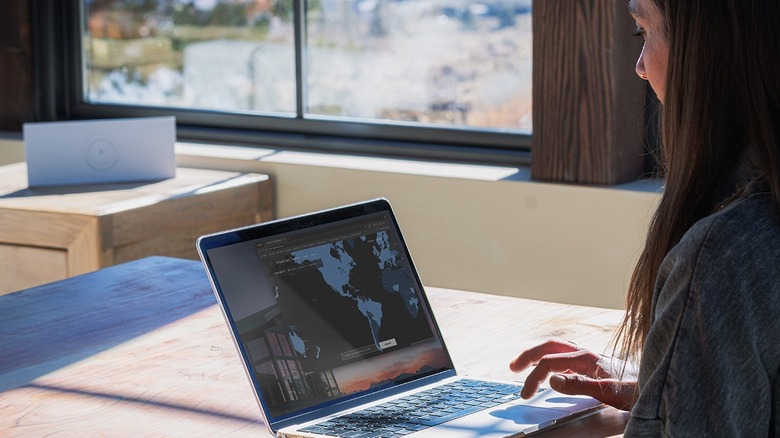 Woman using a laptop with Starlink router in the background