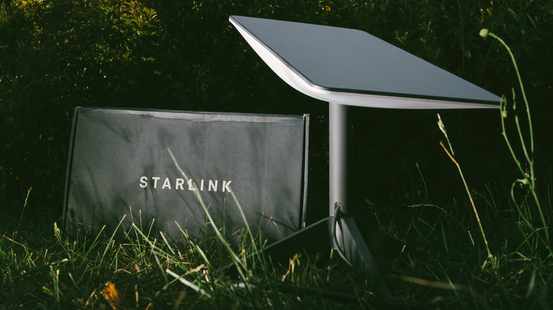 ภาพถ่ายของกล่อง Starlink และดาวเทียมนั่งอยู่บนพื้นหญ้า