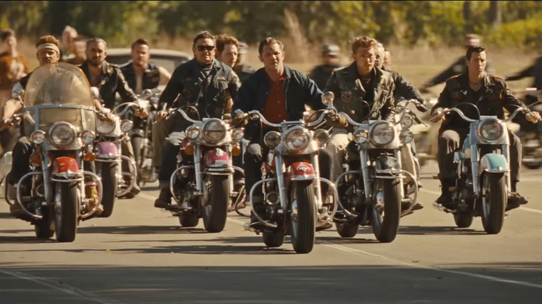 A scene from the movie 'Backriders' showing Tom Hardy and Austin Butler leading a pack of motorcycle club members