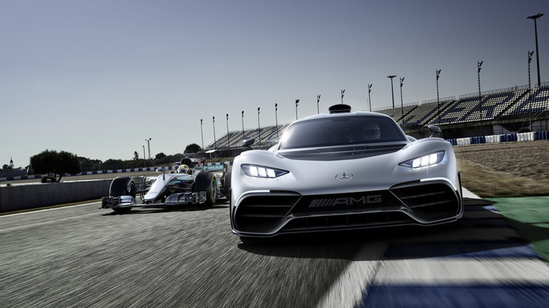 Mercedes-AMG One and Formula 1 car driving together on racetrack, front view