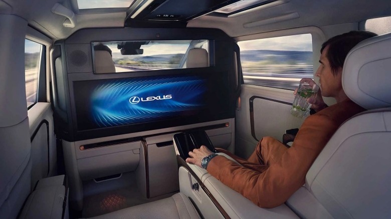 Passenger in back seat of Lexus LM watching the 48-inch display