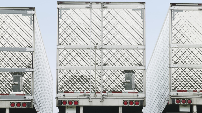 The back of three semi-truck trailers