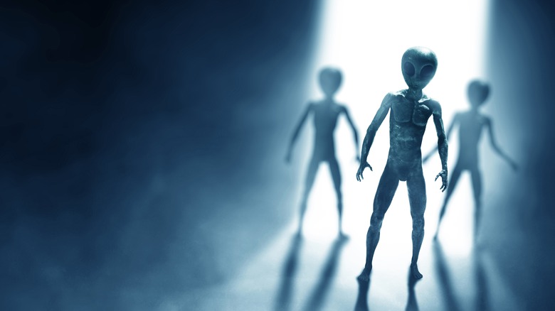 Three aliens in a beam of light