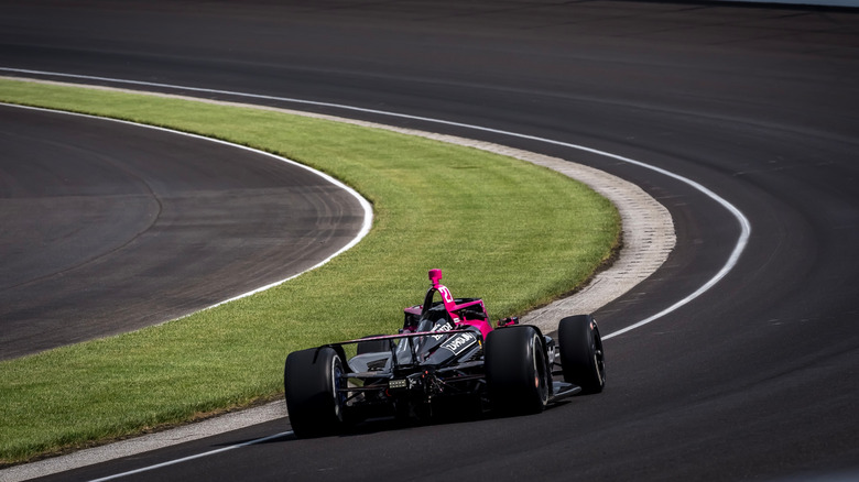 Kyle Kirkwood racing IndyCar around Indianapolis during Free Practice session, rear view