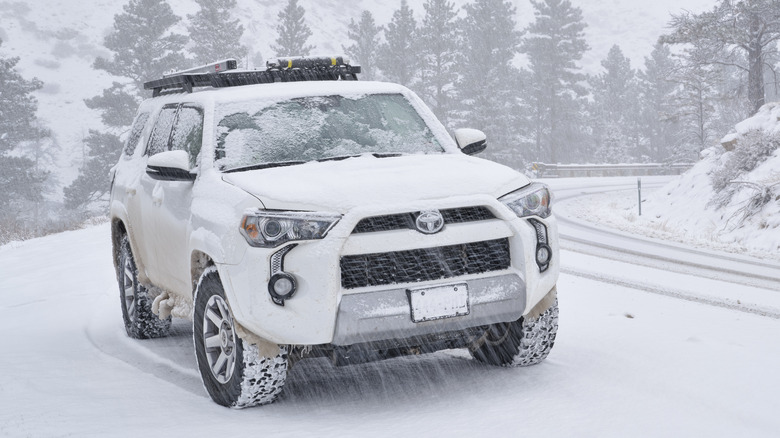 A White Toyota 4Runner driving on snowy hill