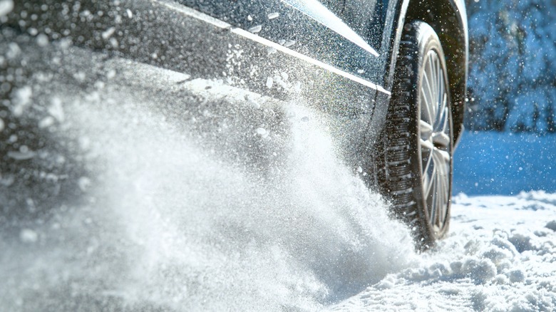 A car throwing snow while accelerating