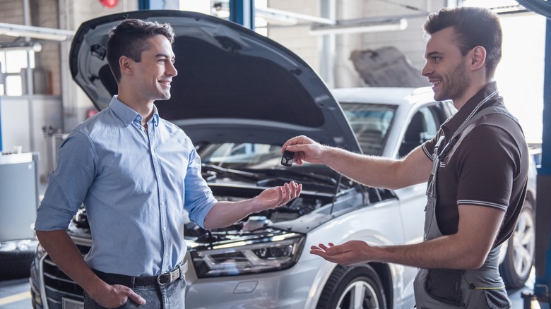 Mechanic giving keys to customer