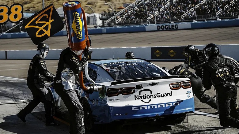 A team fuel up a blue and white Camaro with Sunoco