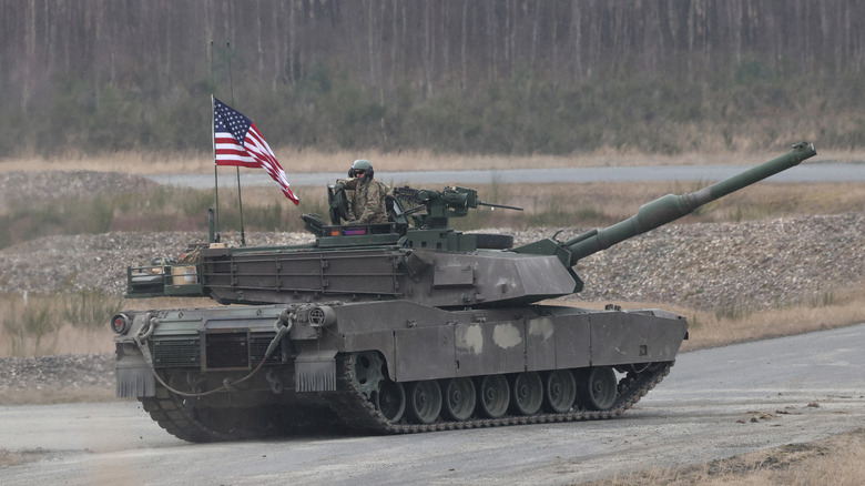 M1 Abrams tank on road flying American flag