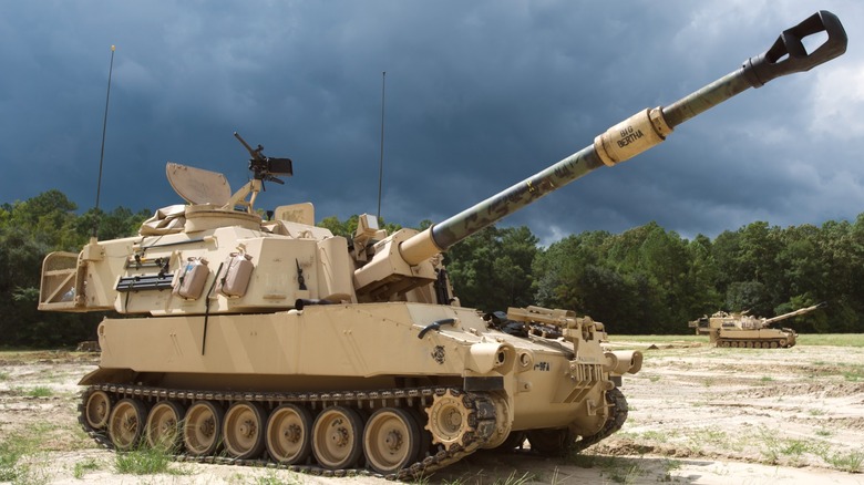 M109A6 tank in field preparing to fire