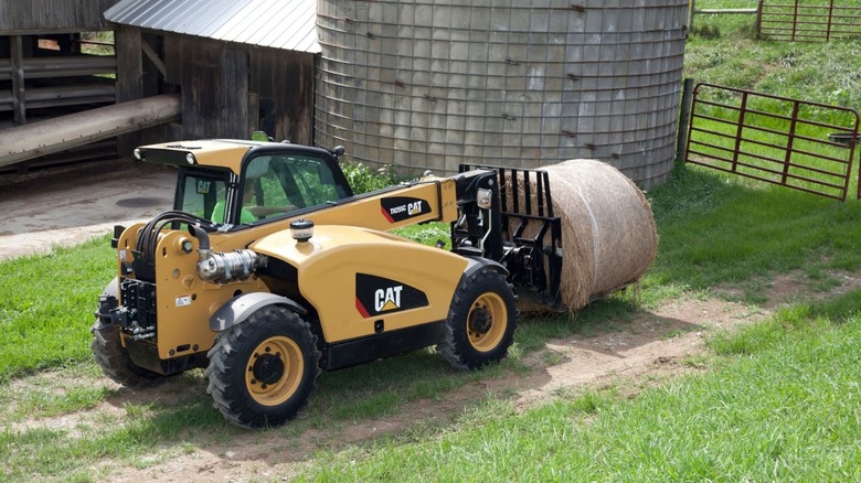 Caterpillar Telehandler moving a bale of hay