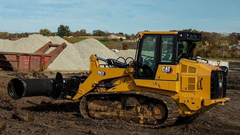 Caterpillar track loader carrying pipe