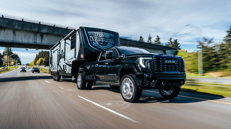 GMC Sierra with camping trailer attached driving down the road