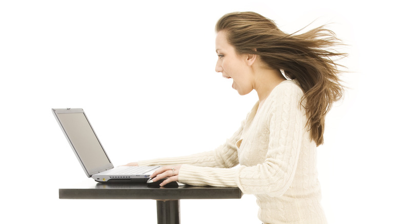 Person sitting in front of laptop with hair blown back, implying very fast speeds