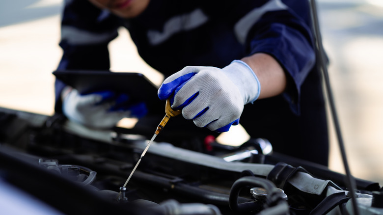 Mechanic checking engine oil