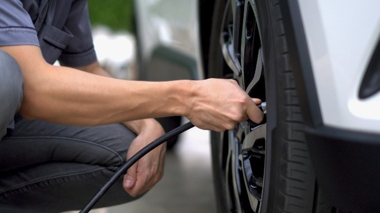 Person putting air in car tire