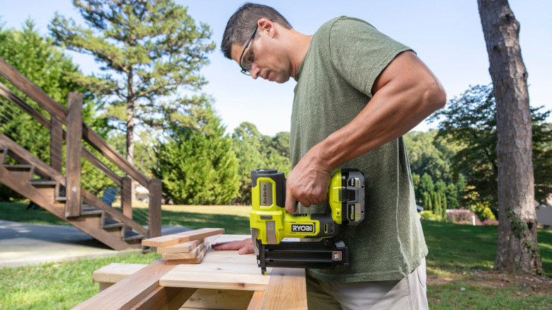 man using ryobi nail gun