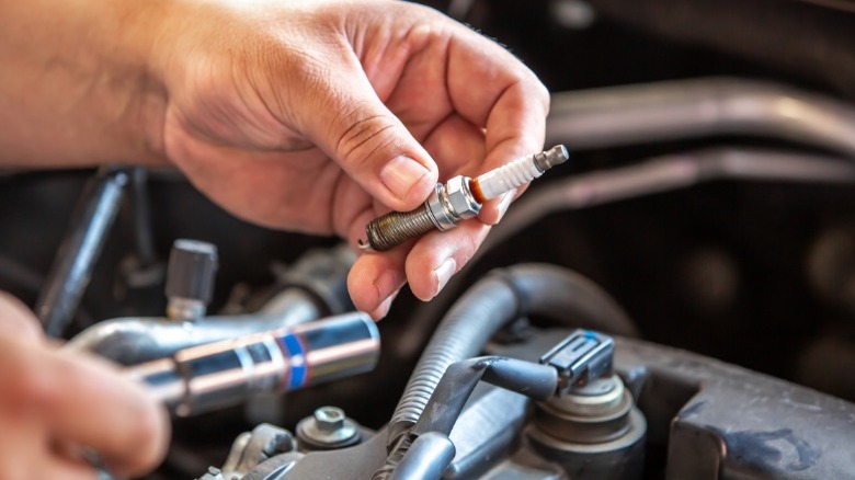 person replacing spark plugs