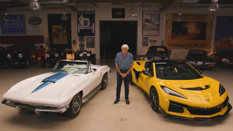 Jay Leno between two Corvettes in his garage