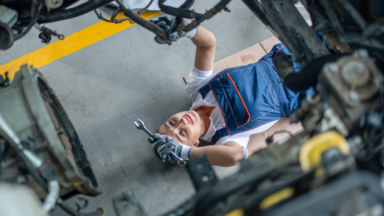 Female mechanic working on car