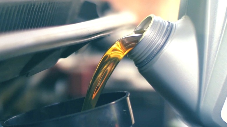 Motor oil being poured into an engine.