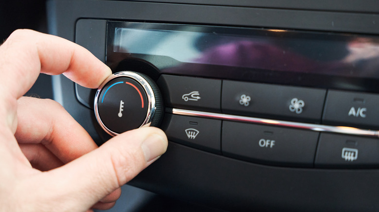 driver turning the fan temperature knob