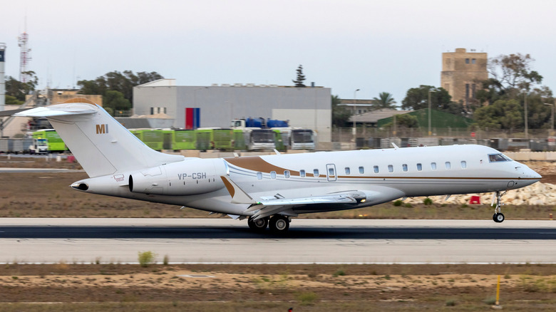 Bombardier Global Express 6500 landing on a runway at sunset