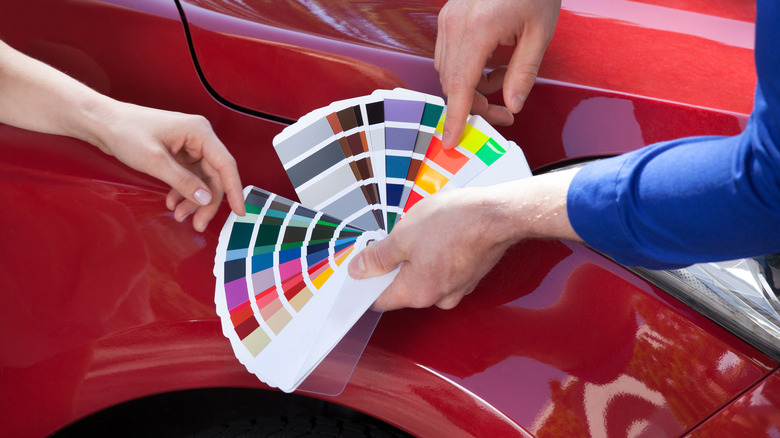 paint swatches held in front of car