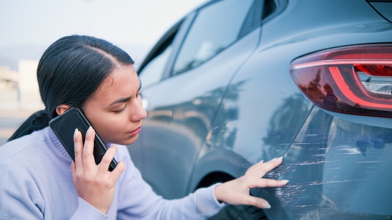 woman assessing car damage