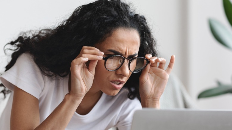 Woman squinting at laptop