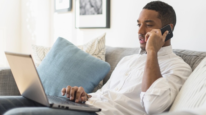 Man on a phone call staring at laptop