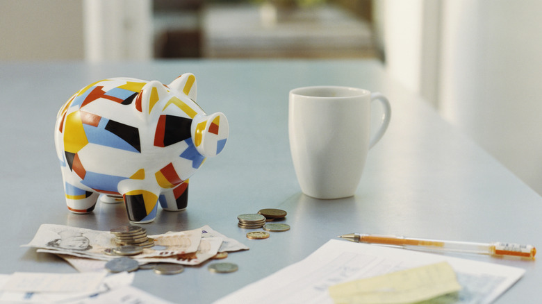 Piggy bank next to white mug