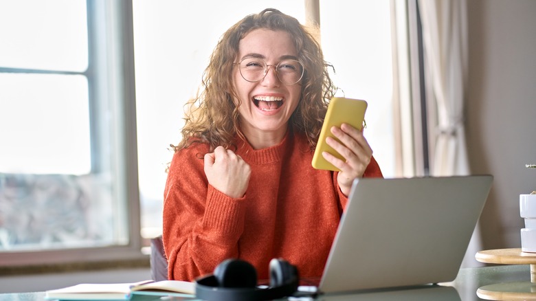 excited person holding smartphone