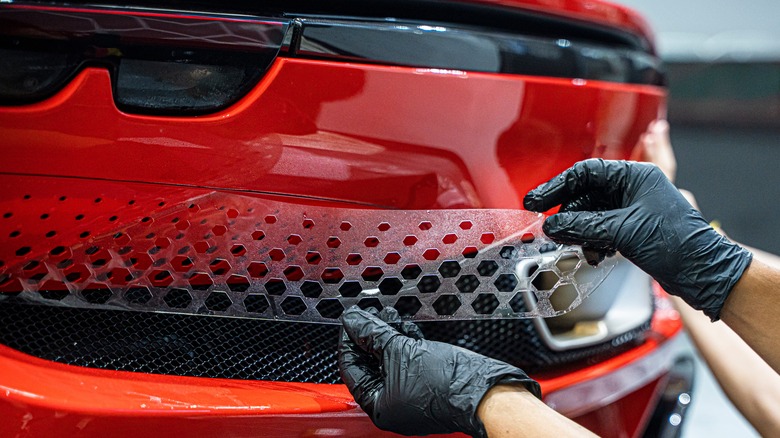 person installing PPF on car