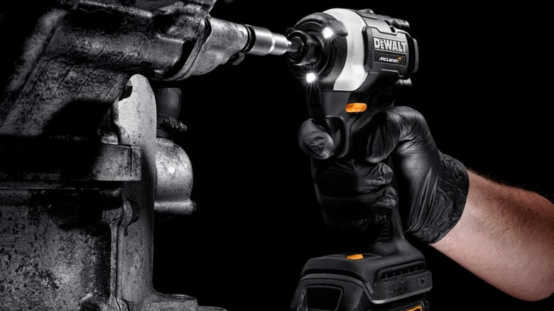 A hand holding a DeWalt-McLaren impact driver.