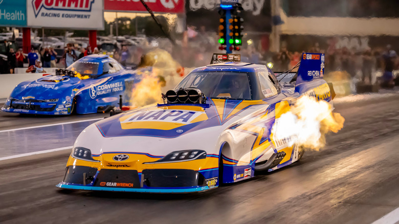 Top fuel funny cars launching on the drag strip