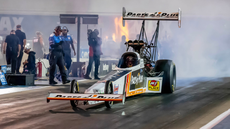 Top fuel drag racer performing pre-staging burnout