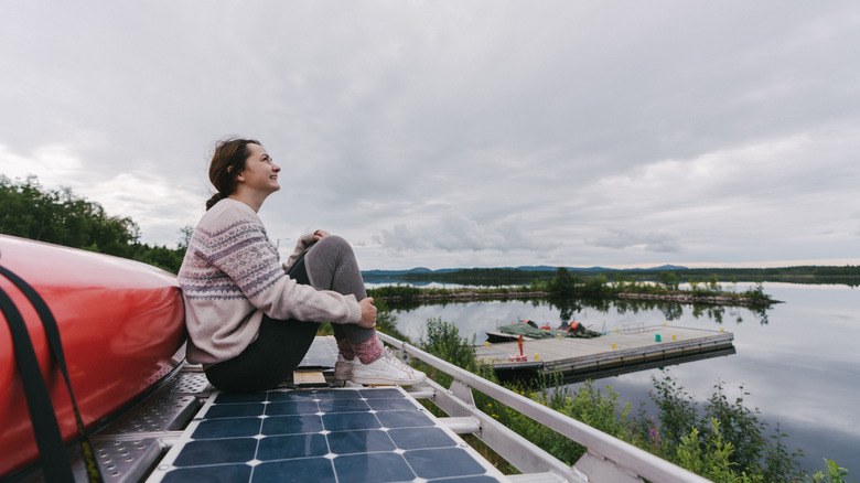 A woman sits on a solar panel